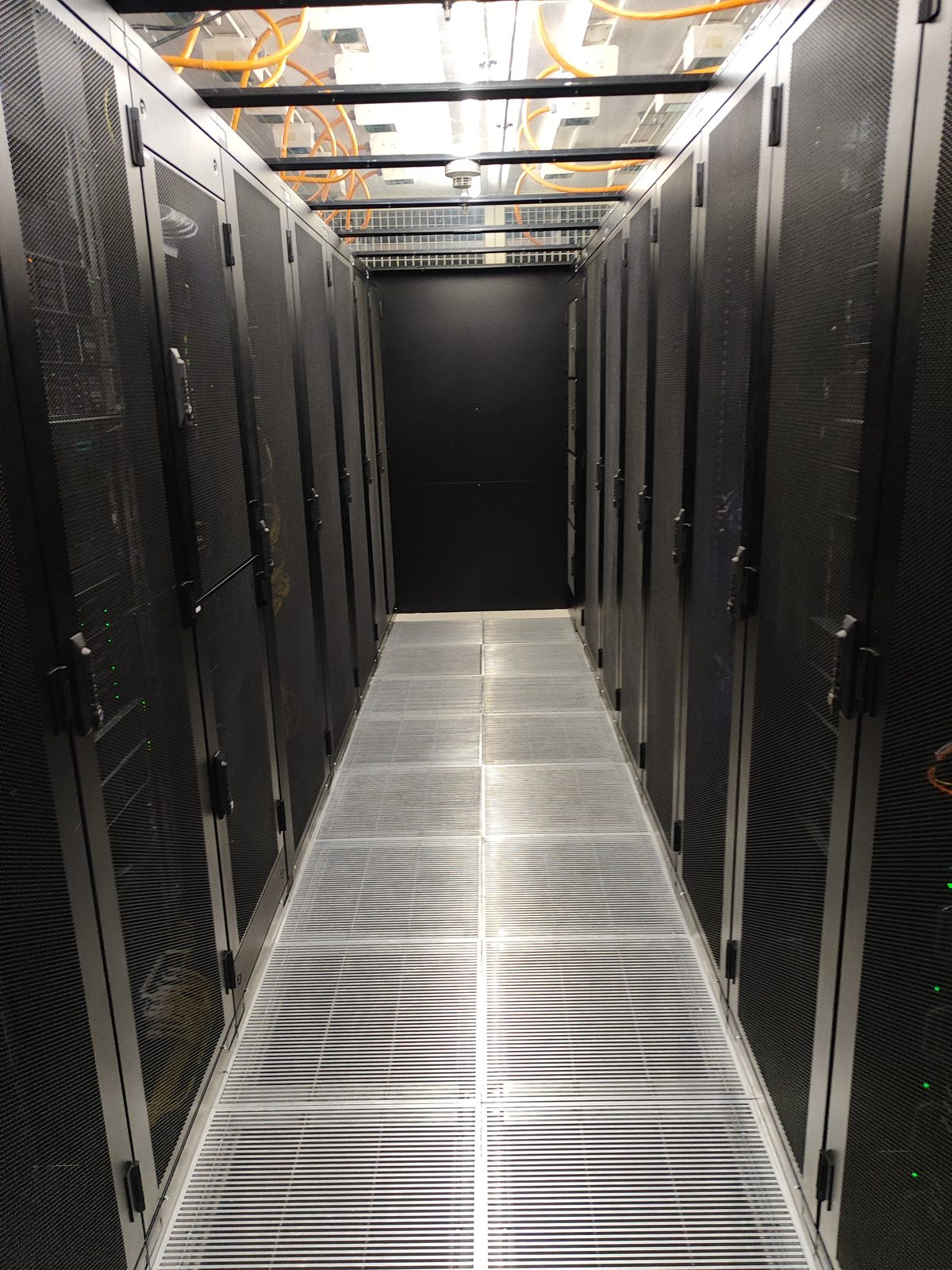 Reihen von Serverschränken im Cold Corridor des Standard-Colocation-Saals des Crissier-Rechenzentrums